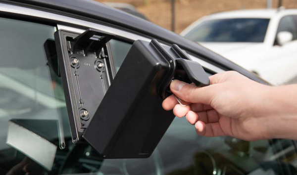 Schlüsselbox ark Scheibenmontage, mit Schlüssel geöffnetem Deckel und geöffneter Schutzklappe mit Schlüssel drin, in Frontalansicht an einer Autoscheibe